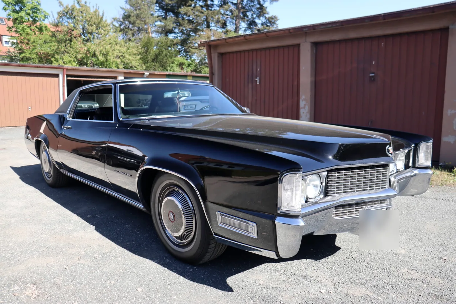 Cadillac Oldtimer bei der Bewertung vor Garagen